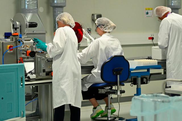 Employees work on a CryoPark production line during a press visit at the industrial site of the French pharmaceutical group Sanofi in Montpellier, in the south of France, on June 16, 2026. The CryoPark is a facility dedicated to the storage and global distribution of biological products and samples at very low temperatures, particularly for messenger RNA vaccines, gene therapies, and other biopharmaceutical innovations. (Photo by Sylvain THOMAS / AFP)