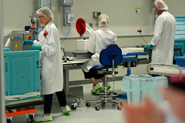 Employees work on a CryoPark production line during a press visit at the industrial site of the French pharmaceutical group Sanofi in Montpellier, in the south of France, on June 16, 2026. The CryoPark is a facility dedicated to the storage and global distribution of biological products and samples at very low temperatures, particularly for messenger RNA vaccines, gene therapies, and other biopharmaceutical innovations. (Photo by Sylvain THOMAS / AFP)