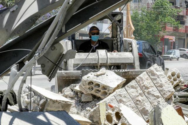 A worker pilots a small excavator to remove the rubble of a destroyed building in the village of Deir Qanoun al-Nahr in southern Lebanon on June 16, 2026. Lebanese state media said that Israeli strikes killed at least four people in the Nabatieh area of the country's south on June 16, despite an announcement that a US-Iran deal included the Israel-Hezbollah war. While violence has declined in Lebanon since the agreement between the US and Iran was announced, Israeli strikes on the south have now killed at least five people since June 15. (Photo by MAHMOUD ZAYYAT / AFP) / 