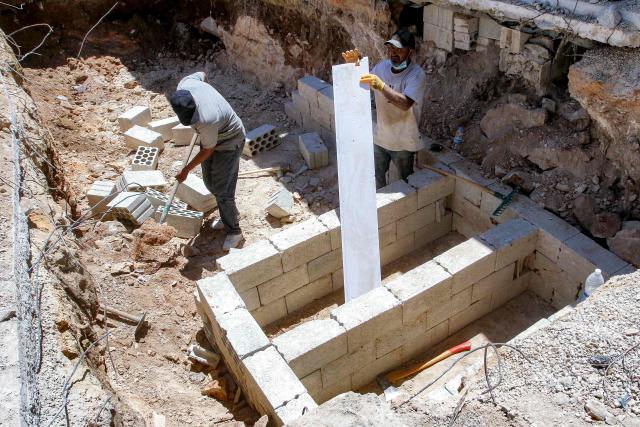 Workers dig and prepare foundations of new graves at the village of Deir Qanoun al-Nahr in southern Lebanon on June 16, 2026. Lebanese state media said that Israeli strikes killed at least four people in the Nabatieh area of the country's south on June 16, despite an announcement that a US-Iran deal included the Israel-Hezbollah war. While violence has declined in Lebanon since the agreement between the US and Iran was announced, Israeli strikes on the south have now killed at least five people since June 15. (Photo by MAHMOUD ZAYYAT / AFP) / 