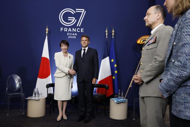 France's President Emmanuel Macron (2nd L) shakes hands with Japan's Prime Minister Sanae Takaichi (L) during a bilateral meeting on the sideline of the G7 summit, in Evian, eastern France, on June 16, 2026. A G7 summit is set to take place June 15 to 17 in the French town of Evian-les-Bains near Switzerland and it will be attended by country leaders as well as the EU's foreign policy chief and ministers from Brazil, Canada, the United Arab Emirates and Turkey. (Photo by Yoan VALAT / POOL / AFP)