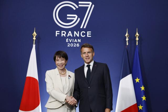 France's President Emmanuel Macron (R) shakes hands with Japan's Prime Minister Sanae Takaichi during a bilateral meeting on the sideline of the G7 summit, in Evian, eastern France, on June 16, 2026. A G7 summit is set to take place June 15 to 17 in the French town of Evian-les-Bains near Switzerland and it will be attended by country leaders as well as the EU's foreign policy chief and ministers from Brazil, Canada, the United Arab Emirates and Turkey. (Photo by Yoan VALAT / POOL / AFP)