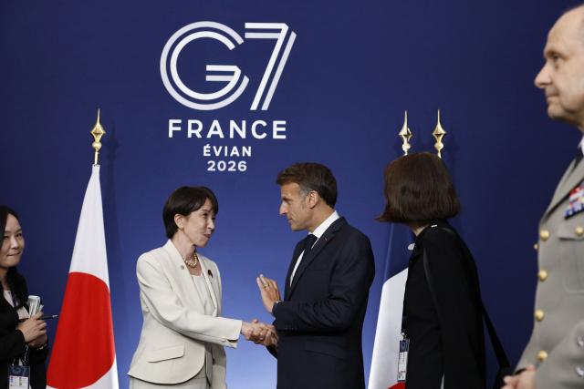 France's President Emmanuel Macron (C-R) shakes hands with Japan's Prime Minister Sanae Takaichi during a bilateral meeting on the sideline of the G7 summit, in Evian, eastern France, on June 16, 2026. A G7 summit is set to take place June 15 to 17 in the French town of Evian-les-Bains near Switzerland and it will be attended by country leaders as well as the EU's foreign policy chief and ministers from Brazil, Canada, the United Arab Emirates and Turkey. (Photo by Yoan VALAT / POOL / AFP)