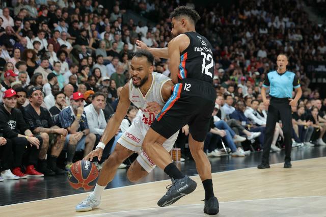 (FILES) AS Monaco's Guard #0 Elie Okobo (L) fights for the ball with Paris Basketball's German Guard #12 Maodo Lo during the French Elite Championship Final 5 Basketball match between Paris Basketball and AS Monaco Basket, at the Adidas Arena Stadium in Paris, on June 24, 2025. For once, and unlike in recent seasons, the lead roles in the french championship final are being played by Frenchmen: Nadir Hifi has been promoted to starting point guard for Paris Basketball, while Elie Okobo and Matthew Strazel have taken on greater responsibilities at Monaco in the absence of Mike James. The three French internationals will face each other again on June 17, 2026, at the Arena Porte de la Chapelle, for the second game of the final showdown of a season with a distinctly blue-white-red flavour, since only one foreign player made it into the starting five of the regular season. (Photo by Thomas SAMSON / AFP)