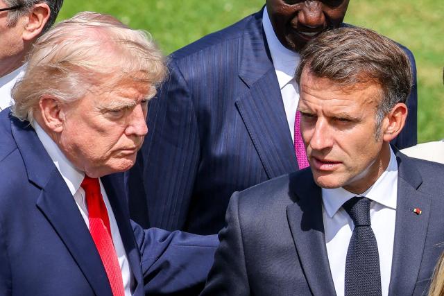US President Donald Trump (L) and France's President Emmanuel Macron talk during a family photograph during the G7 summit, in Evian, eastern France, on June 16, 2026. A G7 summit is set to take place June 15 to 17 in the French town of Evian-les-Bains near Switzerland and it will be attended by country leaders as well as the EU's foreign policy chief and ministers from Brazil, Canada, the United Arab Emirates and Turkey. (Photo by Dominique JACOVIDES / POOL / AFP)