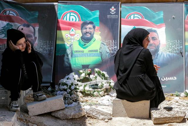 EDITORS NOTE: Graphic content / Shuruq Hariri (R), 32, mourns her dead twin brothers at the local cemetery in the village of Deir Qanoun al-Nahr in southern Lebanon on June 16, 2026. Lebanese state media said that Israeli strikes killed at least four people in the Nabatieh area of the country's south on June 16, despite an announcement that a US-Iran deal included the Israel-Hezbollah war. While violence has declined in Lebanon since the agreement between the US and Iran was announced, Israeli strikes on the south have now killed at least five people since June 15. (Photo by MAHMOUD ZAYYAT / AFP) / 