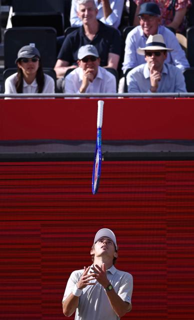 Australia's Alex de Minaur throws his racquet in the air as he reacts whilst playing against Canada's Gabriel Dialloin their men's singles round of 32 tennis match on day two of the ATP HSBC Championships at Queen's Club in west London on June 16, 2026. (Photo by Henry Nicholls / AFP)