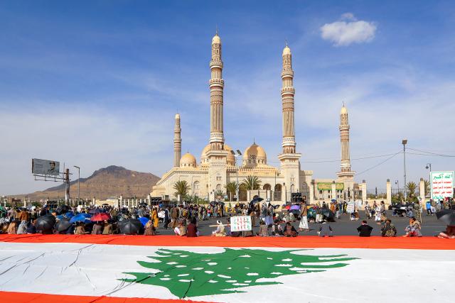 Men sit alongside a giant unfurled Lebanese flag, as supporters of the Iranian-backed Huthi movement gather at a mass rally, denouncing what they perceive to be derogatory comments by the US president regarding the holy city, in Yemen's Huthi-held capital Sanaa on June 16, 2026. US President Donald Trump had on June 13 had 
criticised the presidential library of his predecessor, Democrat Barack Obama, saying "ten years from now [it] will be a 'Mecca' for those who hate America!", drawing backlash from conservative Muslims.

 
He said Monday that loaded oil tankers were moving out of the strait, apparently on a route near to Oman, in a post on his Truth Social platform. (Photo by Mohammed HUWAIS / AFP)
