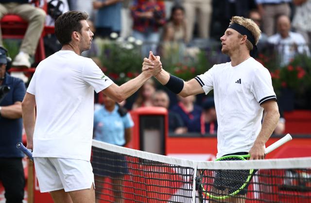 Spain's Alejandro Davidovich Fokina shakes hands with Britain's Cameron Norrie after winning their men's singles round of 32 tennis match on day two of the ATP HSBC Championships at Queen's Club in west London on June 16, 2026. (Photo by Henry NICHOLLS / AFP)