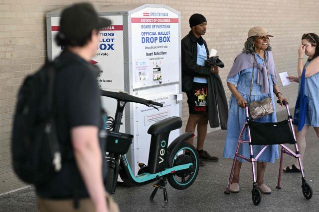 People walk past a drop box at a polling place at the Martin Luther King Jr. Memorial Library during the DC primary elections on June 16, 2026 in Washington, DC. (Photo by Brendan SMIALOWSKI / AFP)