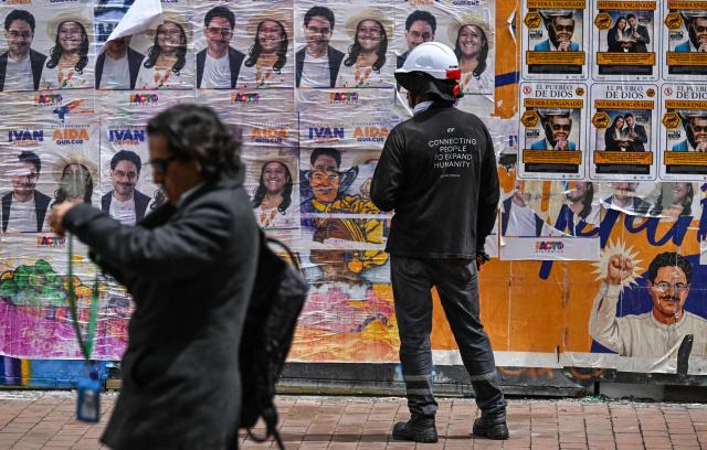 A worker looks at political propaganda of Colombia's presidential candidate for the Pacto Historico party Ivan Cepeda in Bogota on June 16, 2026. Colombia will hold the presidential election runoff on June 21, 2026. (Photo by Juan BARRETO / AFP)