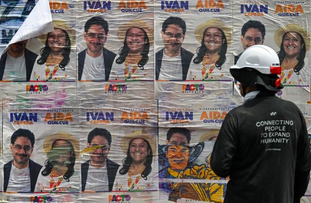 A worker looks at political propaganda of Colombia's presidential candidate for the Pacto Historico party Ivan Cepeda in Bogota on June 16, 2026. Colombia will hold the presidential election runoff on June 21, 2026. (Photo by Juan BARRETO / AFP)
