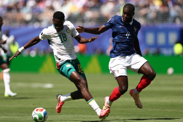 Senegal's forward #18 Ismaila Sarr and France's defender #04 Dayot Upamecano fight for the ball during the 2026 World Cup Group I football match between France and Senegal at the New York/New Jersey Stadium in East Rutherford on June 16, 2026.  (Photo by CHARLY TRIBALLEAU / AFP)
