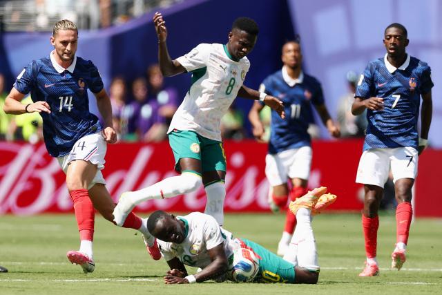 Senegal's forward #10 Sadio Mane (bottom), midfielder #08 Lamine Camara, France's midfielder #14 Adrien Rabiot and forward #07 Ousmane Dembele fight for the ball during the 2026 World Cup Group I football match between France and Senegal at the New York/New Jersey Stadium in East Rutherford on June 16, 2026.  (Photo by CHARLY TRIBALLEAU / AFP)