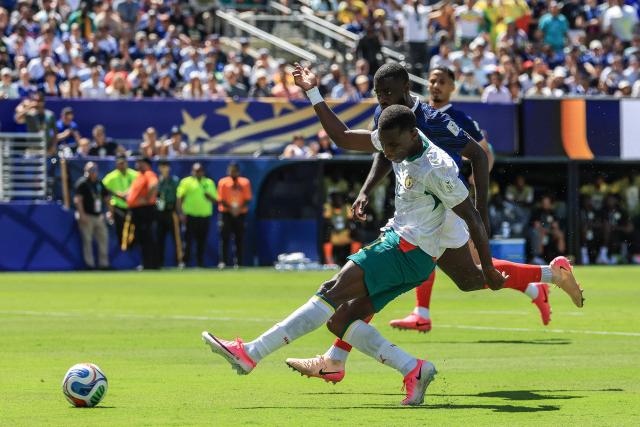 Senegal's forward #11 Nicolas Jackson shoots past France's defender #04 Dayot Upamecano during the 2026 World Cup Group I football match between France and Senegal at the New York/New Jersey Stadium in East Rutherford on June 16, 2026.  (Photo by TIMOTHY A. CLARY / AFP)