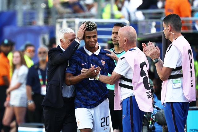 France's forward #20 Desire Doue (C) reatcs with France's head coach Didier Deschamps (L)  during the 2026 World Cup Group I football match between France and Senegal at the New York/New Jersey Stadium in East Rutherford on June 16, 2026.  (Photo by FRANCK FIFE / AFP)