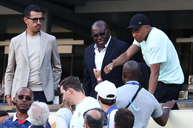 France's forward #10 Kylian Mbappe (R) greets a fan next to his father Wilfried Mbappe after the 2026 World Cup Group I football match between France and Senegal at the New York/New Jersey Stadium in East Rutherford on June 16, 2026.  (Photo by Franck FIFE / AFP)