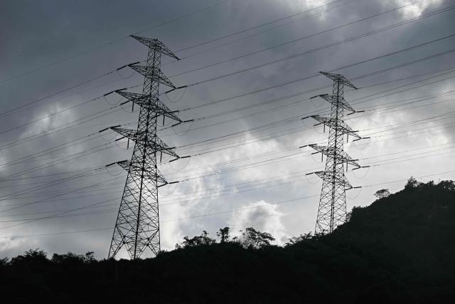 Electricity transmission towers stand on a hillside in Caracas on June 16, 2026. Venezuela signed an agreement with US giant General Electric to begin the recovery of its beleaguered power system, acting president Delcy Rodriguez announced on June 15, 2026. (Photo by Federico PARRA / AFP)