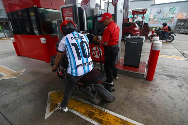 A motorcyclist wearing an Argentina national football team jersey bearing the name of Lionel Messi refuels a motorcycle at a gas station in Tegucigalpa on June 16, 2026. (Photo by Johny Magallanes / AFP)