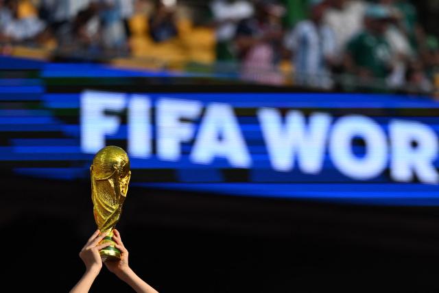 A fan shows a replica of the FIFA World Cup trophy ahead of the 2026 World Cup Group J football match between Argentina and Algeria at the Kansas City Stadium in Kansas City on June 16, 2026.  (Photo by ROBERTO SCHMIDT / AFP)