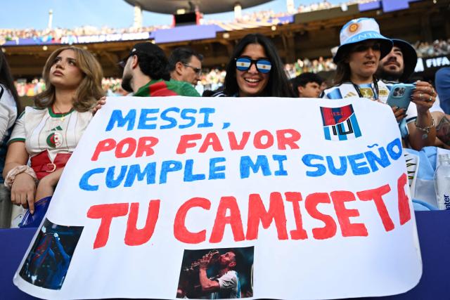 An Argentine fan shows a sign that reads in Spanish "Messi, please make my dream come true, your T-shirt" ahead of the 2026 World Cup Group J football match between Argentina and Algeria at the Kansas City Stadium in Kansas City on June 16, 2026.  (Photo by ROBERTO SCHMIDT / AFP)