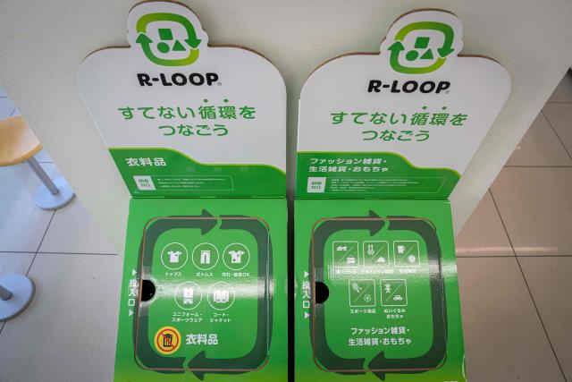 This picture taken on May 13, 2026, shows recycling boxes for clothing, household goods and toys at a FamilyMart convenience store in Tokyo. Under a scorching sun in a Bangkok suburb, a whistle blows and shouts fill the air as dozens of shoppers rush into a warehouse bearing the sign: "Japanese Second-Hand Store". From bags and bicycles to surfboards and suitcases, the Japanese second-hand market is booming, with quality-conscious buyers in other Asian countries increasingly tapping into the circular economy trend. (Photo by Yuichi YAMAZAKI / AFP) / To go with "JAPAN-LIFESTYLE-ENVIRONMENT-RECYCLE,FOCUS' by Montira Rungjirajittranon with Kyoko Hasegawa
