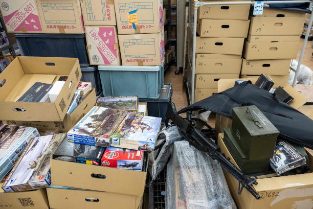 In this photo taken on May 14, 2026, military models and airsoft guns are seen before being auctioned off at the Hamaya wholesale auction site in Higashimatsuyama, Saitama Prefecture. Under a scorching sun in a Bangkok suburb, a whistle blows and shouts fill the air as dozens of shoppers rush into a warehouse bearing the sign: "Japanese Second-Hand Store". From bags and bicycles to surfboards and suitcases, the Japanese second-hand market is booming, with quality-conscious buyers in other Asian countries increasingly tapping into the circular economy trend. (Photo by Andrew CABALLERO-REYNOLDS / AFP) / To go with "JAPAN-LIFESTYLE-ENVIRONMENT-RECYCLE,FOCUS' by Montira Rungjirajittranon with Kyoko Hasegawa