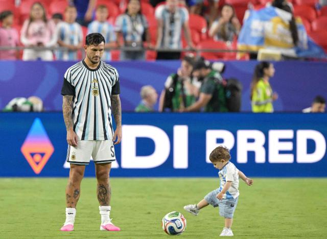 Argentina's midfielder #05 Leandro Paredes looks at a child playing with a ball in the pitch at the end of the 2026 World Cup Group J football match between Argentina and Algeria at the Kansas City Stadium in Kansas City on June 16, 2026.  (Photo by JUAN MABROMATA / AFP)