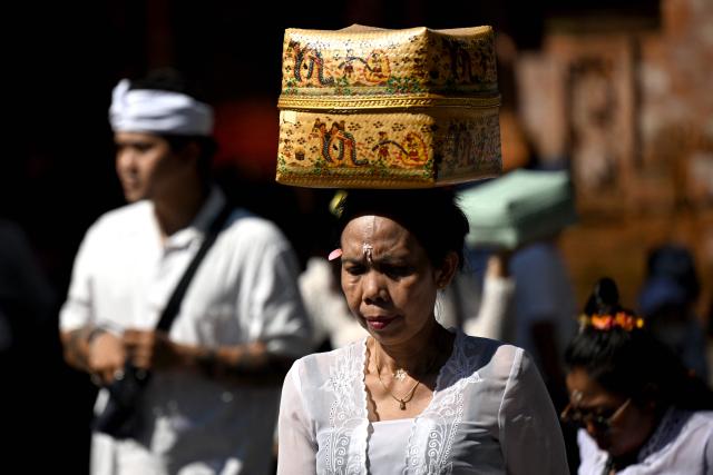 A Hindus woman carries offerings to celebrate the religious festival Galungan at a temple in Denpasar on Indonesia's Bali island on June 17, 2026. Balinese Hindu adherents celebrate Galungan Day or the Earth's celebration to thank God for the creation of the Earth and its content. (Photo by SONNY TUMBELAKA / AFP)