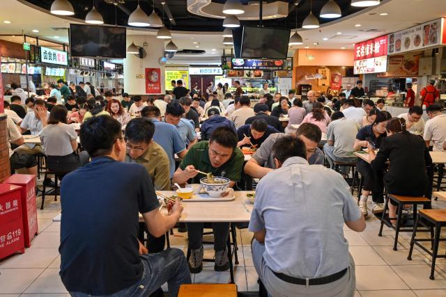 People have lunch at a canteen in Beijing on June 17, 2026. (Photo by ADEK BERRY / AFP)