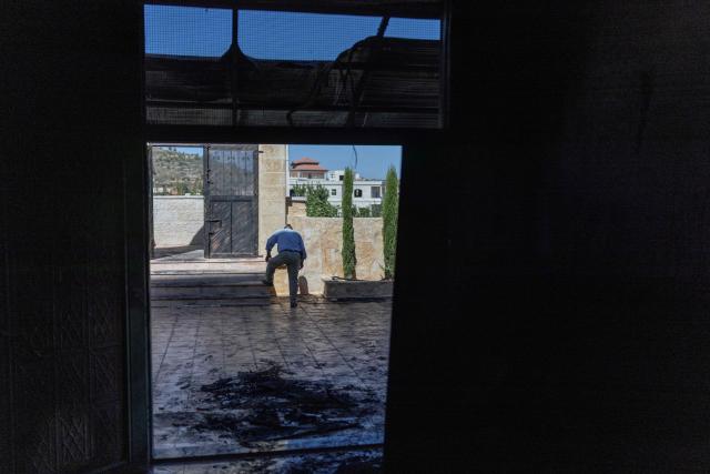 A Palestinian man rinses the soles of his shoes from soot after inspecting the damage inside a mosque reportedly burnt by Israeli settlers over night, in the Israeli occupied West Bank village of Jiljlia, just north of the West Bank city of Ramallah on June 17, 2026. Expanding Israeli settlements has been a policy under successive Israeli governments but has accelerated under the current prime minister's coalition, which is backed by far-right allies. More than 500,000 Israelis now live in the West Bank. excluding east Jerusalem, in settlements that are illegal under international law, among some three million Palestinians. (Photo by ilia YEFIMOVICH / AFP) / 