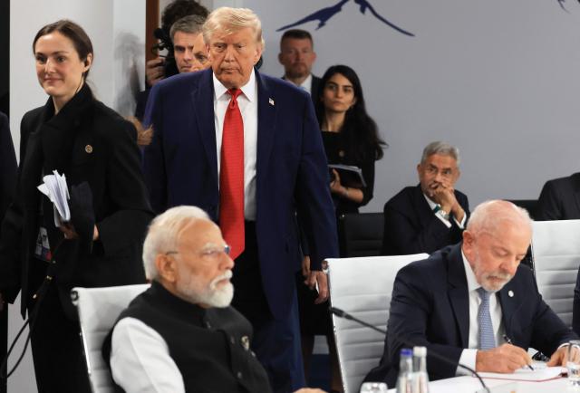 US President Donald Trump arrives as India's Prime Minister Narendra Modi (L) and Brazil's President Luiz Inacio Lula da Silva (R) attend a morning work meeting to “revive balanced, inclusive, and sustainable economic growth for the benefit of all” in the presence of the G7 countries, partner countries, the International Monetary Fund, and the OECD, as part of the G7 summit, in Evian, eastern France, on June 17, 2026. G7 leaders will discuss on June 17, 2026, the security risks posed by AI and social media on the last day of a summit dominated by US the President, before host French President  dines with his US counterpart at the Palace of Versailles. The three-day summit of the leaders of Canada, France, Germany, Italy, Japan,B ritain and the United States has focused intensely on the US' deal to end the war with Iran and efforts to pressure Russia into brokering peace with Ukraine. (Photo by Ludovic MARIN / AFP)