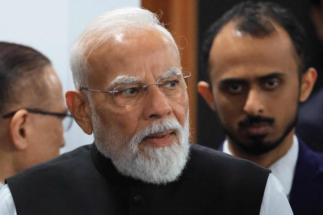 India's Prime Minister Narendra Modi gestures as he arrives to attend a morning work meeting to “revive balanced, inclusive, and sustainable economic growth for the benefit of all” in the presence of the G7 countries, partner countries, the International Monetary Fund, and the OECD, as part of the G7 summit, in Evian, eastern France, on June 17, 2026. G7 leaders will discuss on June 17, 2026, the security risks posed by AI and social media on the last day of a summit dominated by US the President, before host French President  dines with his US counterpart at the Palace of Versailles. The three-day summit of the leaders of Canada, France, Germany, Italy, Japan,B ritain and the United States has focused intensely on the US' deal to end the war with Iran and efforts to pressure Russia into brokering peace with Ukraine. (Photo by Ludovic MARIN / AFP)