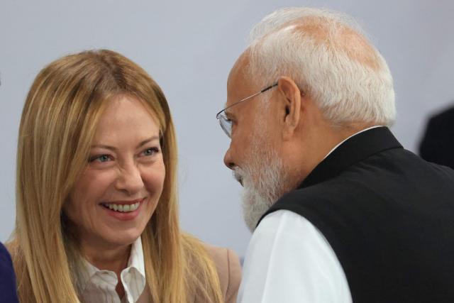 TOPSHOT - Italy's Prime Minister Giorgia Meloni (L) speaks with India's Prime Minister Narendra Modi ahead of a morning work meeting to “revive balanced, inclusive, and sustainable economic growth for the benefit of all” in the presence of the G7 countries, partner countries, the International Monetary Fund, and the OECD, as part of the G7 summit, in Evian, eastern France, on June 17, 2026. G7 leaders will discuss on June 17, 2026, the security risks posed by AI and social media on the last day of a summit dominated by US the President, before host French President  dines with his US counterpart at the Palace of Versailles. The three-day summit of the leaders of Canada, France, Germany, Italy, Japan,B ritain and the United States has focused intensely on the US' deal to end the war with Iran and efforts to pressure Russia into brokering peace with Ukraine. (Photo by Ludovic MARIN / AFP)