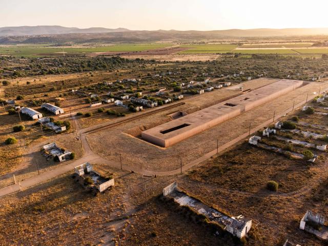 This aerial view shows The Rivesaltes Camp Memorial and The Joffre Camp site at Salses Le Chateau in the Pyrenees-Orientales department in south-western France on June 17, 2026. Bearing painful memories, the museum of the Rivesaltes camp (Pyrйnйes-Orientales) — which over the course of the 20th century housed Spanish refugees, Jews, Roma and Harkis — has unveiled a new permanent exhibition, was inaugurated on May 29, 2026, to defend “historical truth” against the “populisms” that threaten it. (Photo by Jc Milhet / AFP)