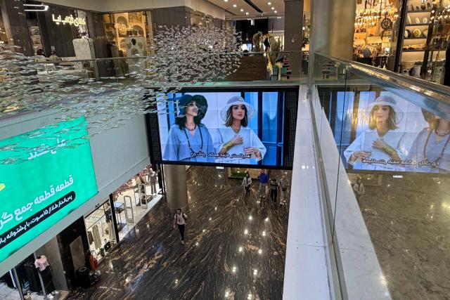 A large screen hangs from the ceiling of a large shopping mall in the capital Tehran on June 17, 2026. The first tankers carrying Iranian oil exited a US blockade in the Strait of Hormuz, a tracking website said on June 17, two days before Washington and Tehran launch talks on an agreed peace deal still scant on details -- including Iran's nuclear programme and the lifting of sanctions. (Photo by ATTA KENARE / AFP) / 