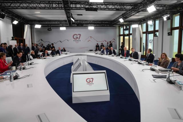 (L side, from L) IMF Managing Director Kristalina Georgieva, South Korea's President Lee Jae-myung, India's Prime Minister Narendra Modi, Brazil's President Luiz Inacio Lula da Silva and Kenya's President William Ruto and (R side, from L) Germany’s Chancellor Friedrich Merz, Britain's Prime Minister Keir Starmer, US President Donald Trump, France's President Emmanuel Macron, Canada’s Prime Minister Mark Carney, Italy's Prime Minister Giorgia Meloni and Japan's Prime Minister Sanae Takaichi attend a morning work meeting to “revive balanced, inclusive, and sustainable economic growth for the benefit of all” in the presence of the G7 countries, partner countries, the International Monetary Fund, and the OECD, as part of the G7 summit, in Evian, eastern France, on June 17, 2026. G7 leaders will discuss on June 17, 2026, the security risks posed by AI and social media on the last day of a summit dominated by US the President, before host French President  dines with his US counterpart at the Palace of Versailles. The three-day summit of the leaders of Canada, France, Germany, Italy, Japan,B ritain and the United States has focused intensely on the US' deal to end the war with Iran and efforts to pressure Russia into brokering peace with Ukraine. (Photo by Ludovic MARIN / AFP)