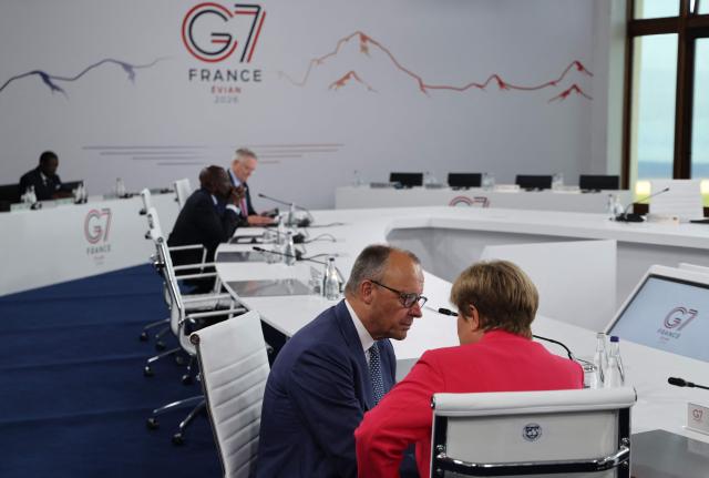 Germany’s Chancellor Friedrich Merz (L) speaks with IMF Managing Director Kristalina Georgieva (R) ahead of a morning work meeting to “revive balanced, inclusive, and sustainable economic growth for the benefit of all” in the presence of the G7 countries, partner countries, the International Monetary Fund, and the OECD, as part of the G7 summit, in Evian, eastern France, on June 17, 2026. G7 leaders will discuss on June 17, 2026, the security risks posed by AI and social media on the last day of a summit dominated by US the President, before host French President  dines with his US counterpart at the Palace of Versailles. The three-day summit of the leaders of Canada, France, Germany, Italy, Japan,B ritain and the United States has focused intensely on the US' deal to end the war with Iran and efforts to pressure Russia into brokering peace with Ukraine. (Photo by Ludovic MARIN / AFP)