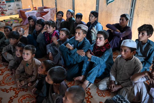 Refugee children attend a class inside a temporary setup at Nasaji Pul village in the Daman district of Afghanistan's Kandahar on June 17, 2026. (Photo by Sanaullah SEIAM / AFP)
