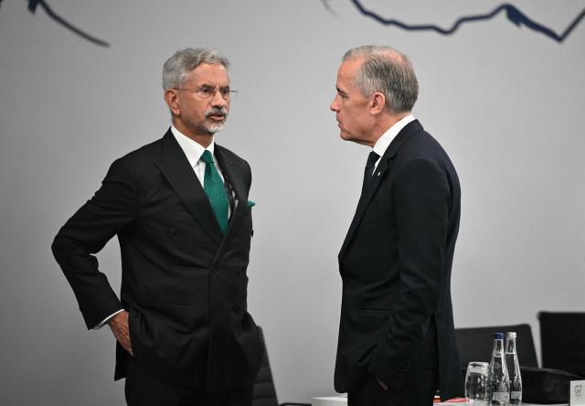 India's Foreign Minister Subrahmanyam Jaishankar (L) speaks with Canada’s Prime Minister Mark Carney ahead of a morning work meeting to “revive balanced, inclusive, and sustainable economic growth for the benefit of all” in the presence of the G7 countries, partner countries, the International Monetary Fund, and the OECD, as part of the G7 summit, in Evian, eastern France, on June 17, 2026. G7 leaders will discuss on June 17, 2026, the security risks posed by AI and social media on the last day of a summit dominated by US the President, before host French President  dines with his US counterpart at the Palace of Versailles. The three-day summit of the leaders of Canada, France, Germany, Italy, Japan,B ritain and the United States has focused intensely on the US' deal to end the war with Iran and efforts to pressure Russia into brokering peace with Ukraine. (Photo by Mandel NGAN / POOL / AFP)
