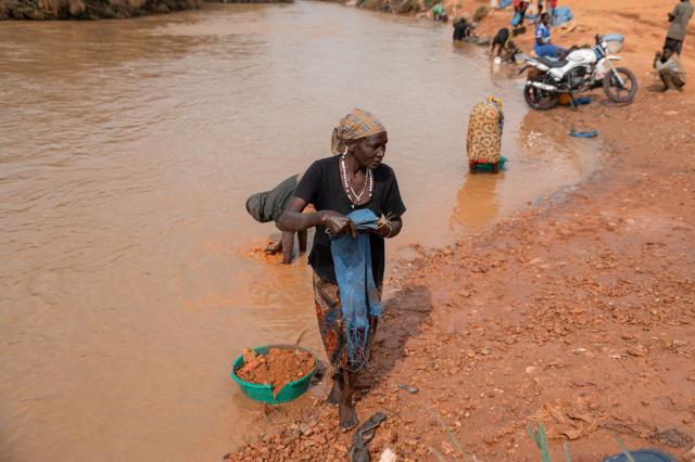Women artisanal miners wash sand and rocks containing traces of gold in the Iga Barriere River, near the gold-trading hub of Iga Barriere, Ituri Province, on June 16, 2026. The latest Ebola outbreak in the Democratic Republic of the Congo, declared on May 15, 2026, has mainly affected the remote, conflict-weary northeastern province of Ituri. Health officials warn that population movements linked to artisanal mining, displacement and insecurity are hampering containment efforts in a region where no approved vaccine exists for this Ebola strain. (Photo by Jospin Mwisha / AFP)