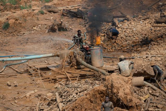 Miners work inside an artisanal mining pit, operating a suction pipe to transport rock to the surface, where women sort material containing gold particles at a mine in Mongbwalu, Ituri Province, on June 16, 2026. The latest Ebola outbreak in the Democratic Republic of the Congo, declared on May 15, 2026, has mainly affected the remote, conflict-weary northeastern province of Ituri. Health officials warn that population movements linked to artisanal mining, displacement and insecurity are hampering containment efforts in a region where no approved vaccine exists for this Ebola strain. (Photo by Jospin Mwisha / AFP)