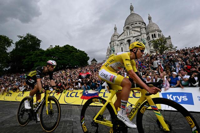 (FILES) UAE Team Emirates - XRG team's Slovenian rider Tadej Pogacar (R) wearing the overall leader's yellow jersey and Team Visma - Lease a bike team's Belgian rider Wout van Aert cycle past the Sacre-Coeur Basilica on the Butte de Montmartre during the 21st and final stage of the 112th edition of the Tour de France cycling race, 132.3 km between Mantes-la-Ville and Paris' Champs-Elysees Avenue, on July 27, 2025. Belgian rider Wout van Aert will miss the Tour de France with an elbow injury, his Visma team announced on June 17, 2026. "The Belgian is still dealing with the effects of an elbow injury and has not recovered in time to start the Tour de France at the required level," the team said. (Photo by Loic VENANCE / AFP)