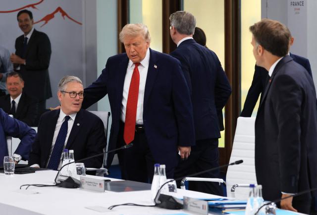 US President Donald Trump (C) gestures next to Britain's Prime Minister Keir Starmer (L) and France's President Emmanuel Macron (R) as they attend a morning work meeting to “revive balanced, inclusive, and sustainable economic growth for the benefit of all” in the presence of the G7 countries, partner countries, the International Monetary Fund, and the OECD, as part of the G7 summit, in Evian, eastern France, on June 17, 2026. G7 leaders will discuss on June 17, 2026, the security risks posed by AI and social media on the last day of a summit dominated by US the President, before host French President  dines with his US counterpart at the Palace of Versailles. The three-day summit of the leaders of Canada, France, Germany, Italy, Japan,B ritain and the United States has focused intensely on the US' deal to end the war with Iran and efforts to pressure Russia into brokering peace with Ukraine. (Photo by Ludovic MARIN / AFP)
