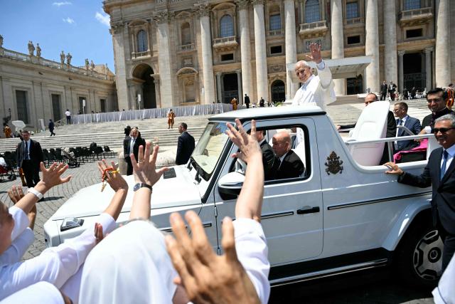 Pope Leo XIV waves to the crowd at the end of the weekly general audience at St Peter's Square in The Vatican on May 17, 2026. (Photo by Andreas SOLARO / AFP)
