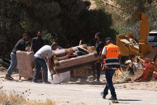 Palestinian men help remove the furniture as Israeli bulldozers demolish a Palestinian home (unseen), which the Israeli authorities say was built without permission, in Ar-Rifaiyya village, south of the Israeli-occupied Palestinian West Bank city of Hebron on June 17, 2026. Israel, whose army has occupied the West Bank since 1967, demolishes the homes of Palestinians which it says have been built without a permit. (Photo by HAZEM BADER / AFP) / 