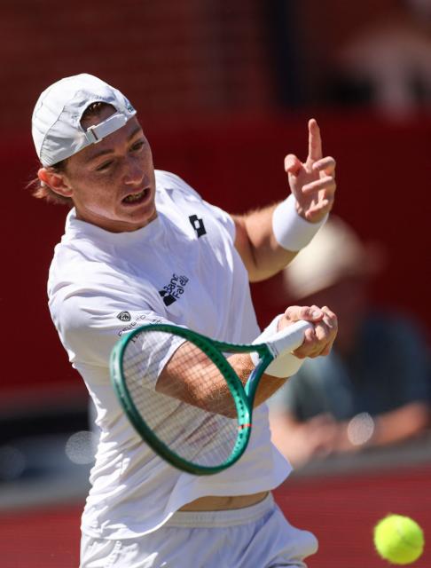 Peru's Ignacio Buse hits a return against Brandon Nakashima of the US during their men's singles round of 16 tennis match on day three of the ATP HSBC Championships at Queen's Club in west London on June 17, 2026. (Photo by Adrian Dennis / AFP)