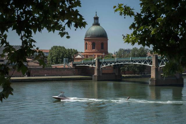 A person practises waterskiing on the Garonne river in Toulouse, southwestern France on June 17, 2026. A heatwave is set to hit France on June 17 and continue for several days with temperatures expected to reach up to 40°C in some areas on June 21, the first day of summer. (Photo by Ed JONES / AFP)