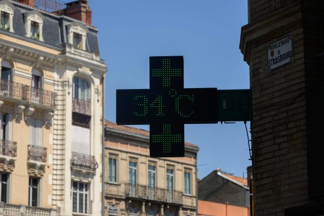 A photograph taken on June 17, 2026 shows a pharmacy sign displaying the temperature, 34 degrees celsius, in Toulouse, southwestern France. A heatwave is set to hit France on June 17 and continue for several days with temperatures expected to reach up to 40°C in some areas on June 21, the first day of summer. (Photo by Ed JONES / AFP)