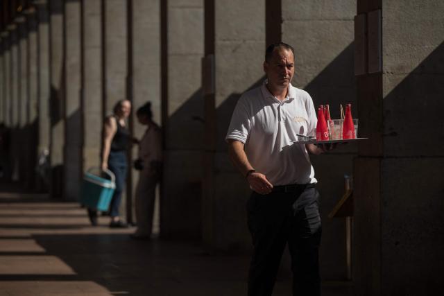 A waiter delivers beverages to customers at a cafe in Toulouse, southwestern France on June 17, 2026. A heatwave is set to hit France on June 17 and continue for several days with temperatures expected to reach up to 40°C in some areas on June 21, the first day of summer. (Photo by Ed JONES / AFP)